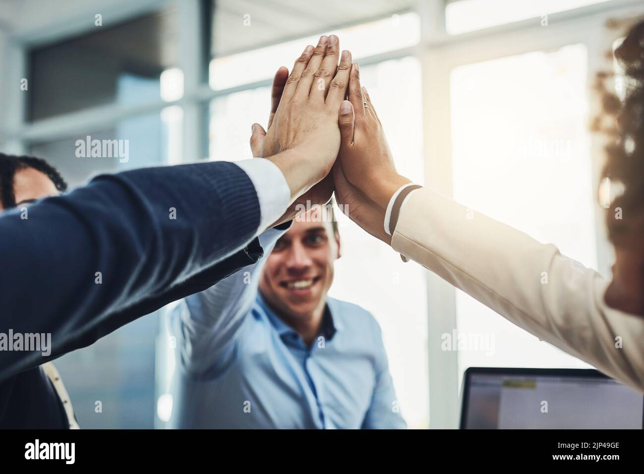 Lavoro di squadra, partnership e divertimento con un gruppo diversificato che unisce le mani per un alto cinque durante la costruzione del team. Colleghi che si riuniscono e mostrano sostegno Foto Stock