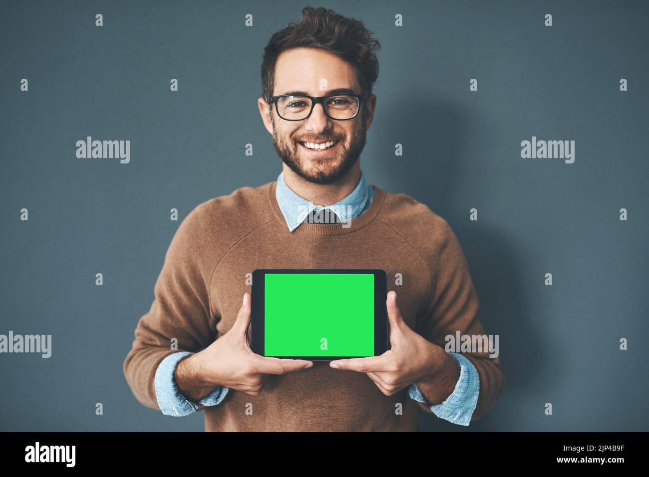 Schermo verde, spazio di copia e tasto chroma sul monitor del tablet per siti Web, marketing e promozioni. Ritratto di sorridente, felice ed eccitato web designer Foto Stock