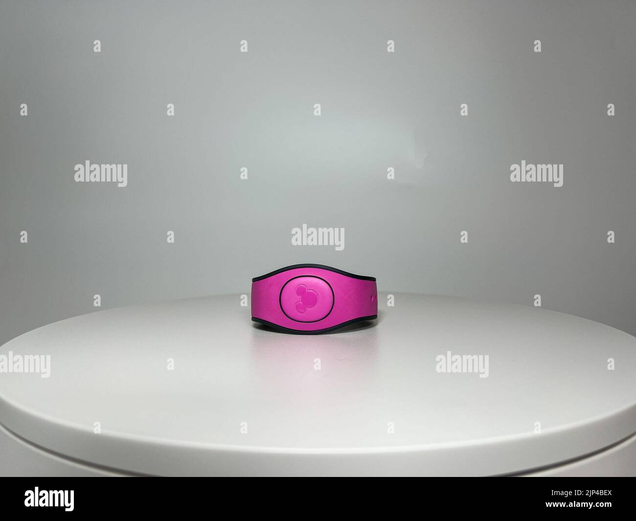 Orlando, FL USA - 11 agosto 2022: Una Magic Band rosa che viene utilizzata come biglietto per entrare nei parchi a tema del Disney World. Foto Stock