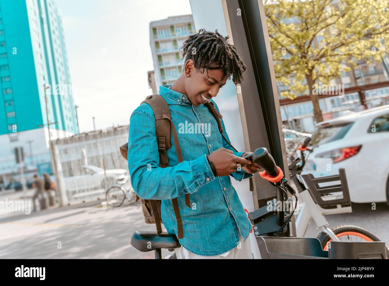Ragazzo che guarda lo smartphone vicino alla bicicletta Foto Stock
