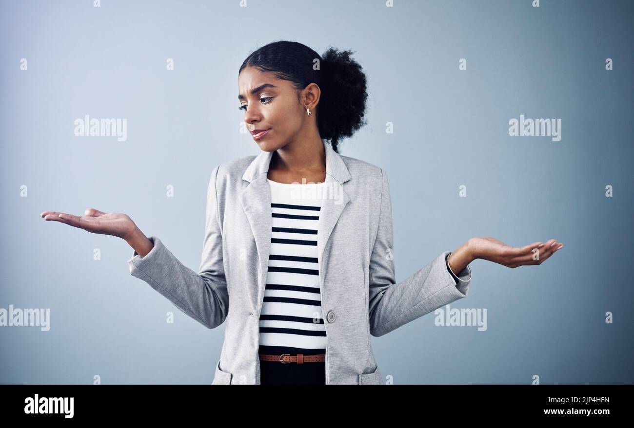 Decisioni, scelte e opzioni con una giovane donna d'affari confrontando e pesando decisioni diverse con copyspace in studio contro un grigio Foto Stock