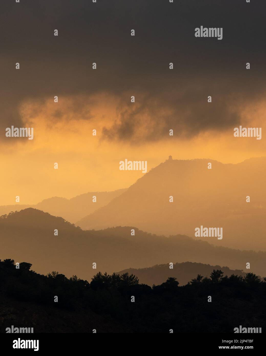 Tramonto con cielo nuvoloso e drammatica luce del sole arancione sopra montagna Troodos montagne Cipro Foto Stock