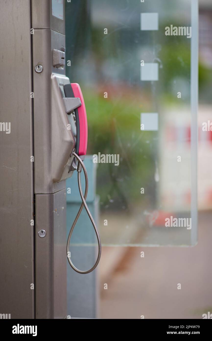 Un telefono in uno stand con pareti trasparenti in città Foto Stock