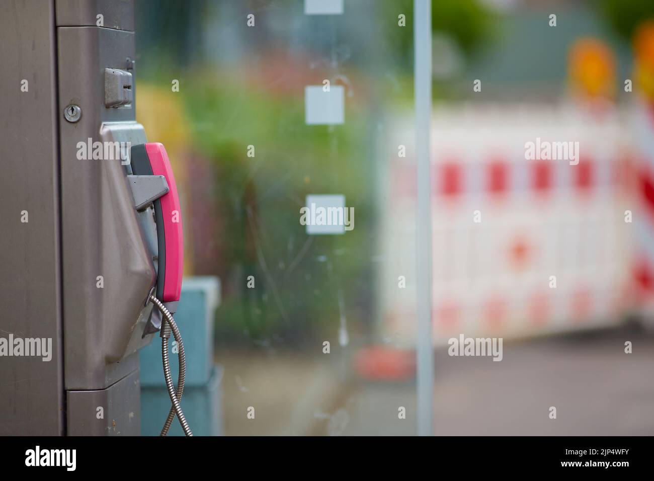 Un telefono in uno stand con pareti trasparenti in città Foto Stock