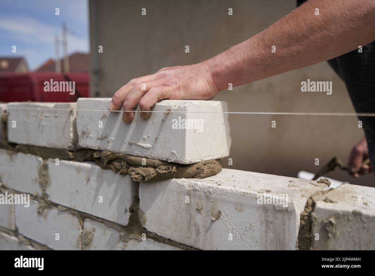 Muratore costruisce pareti da mattoni, primo piano Foto Stock