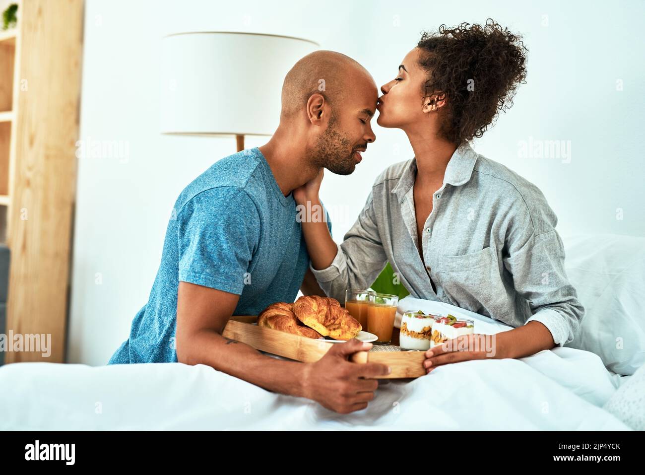 Mi rovina con il suo amore: Una giovane coppia affettuosa che fa colazione a letto. Foto Stock