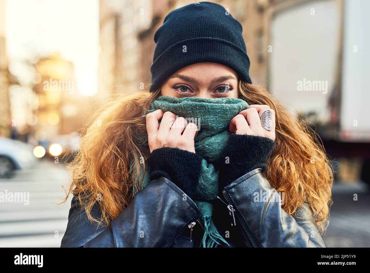 Im non solo un'altra ragazza urbana. Una donna che copre la bocca con la sua sciarpa mentre fuori in città. Foto Stock