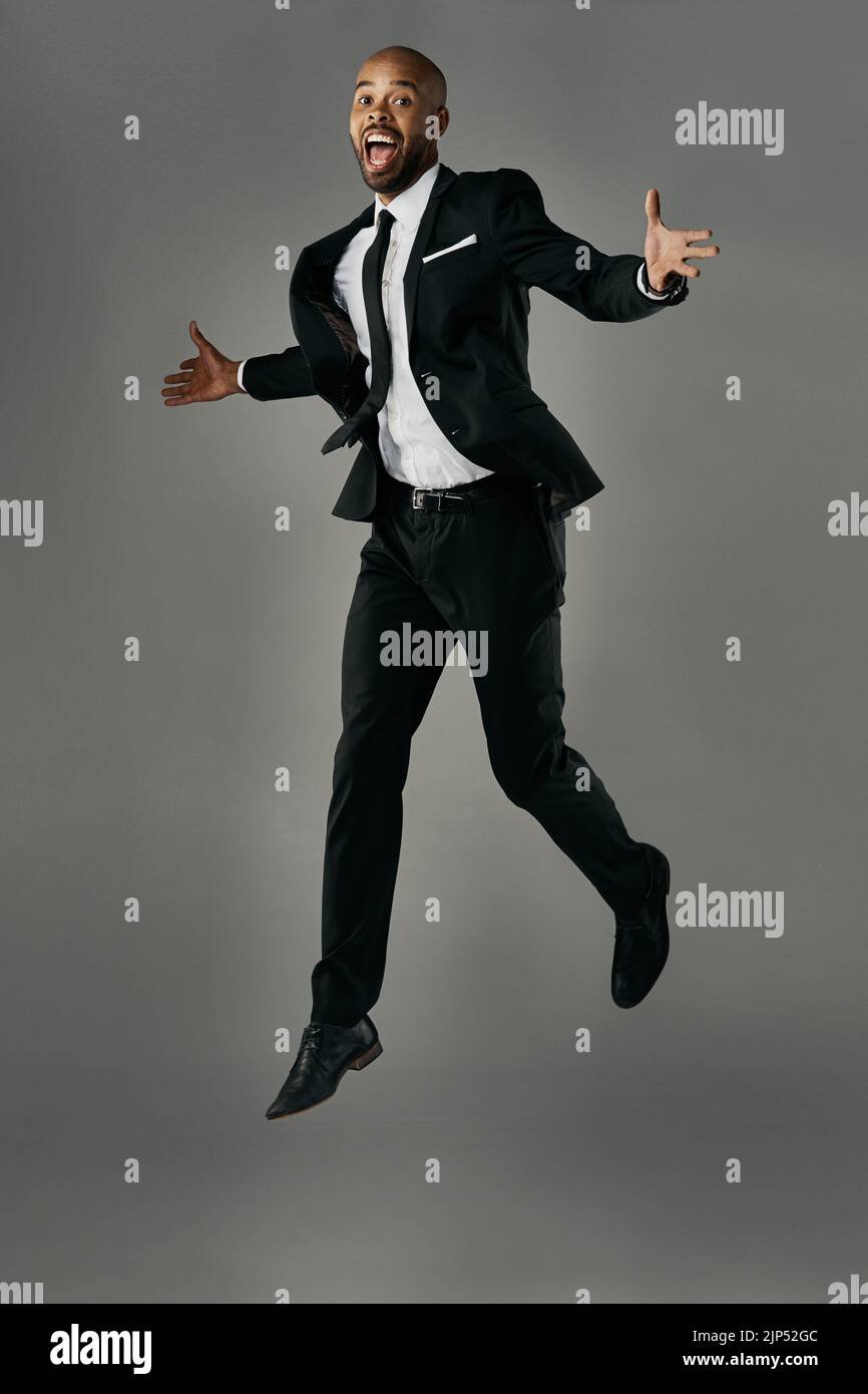 Nuove vette. Studio ritratto di un bel giovane uomo d'affari su uno sfondo grigio. Foto Stock