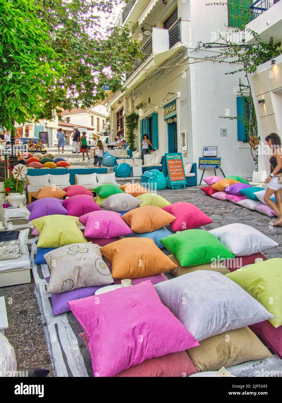Un'immagine verticale di un accogliente caffè con cuscini colorati nella principale città dell'isola di Skiathos, in Grecia Foto Stock