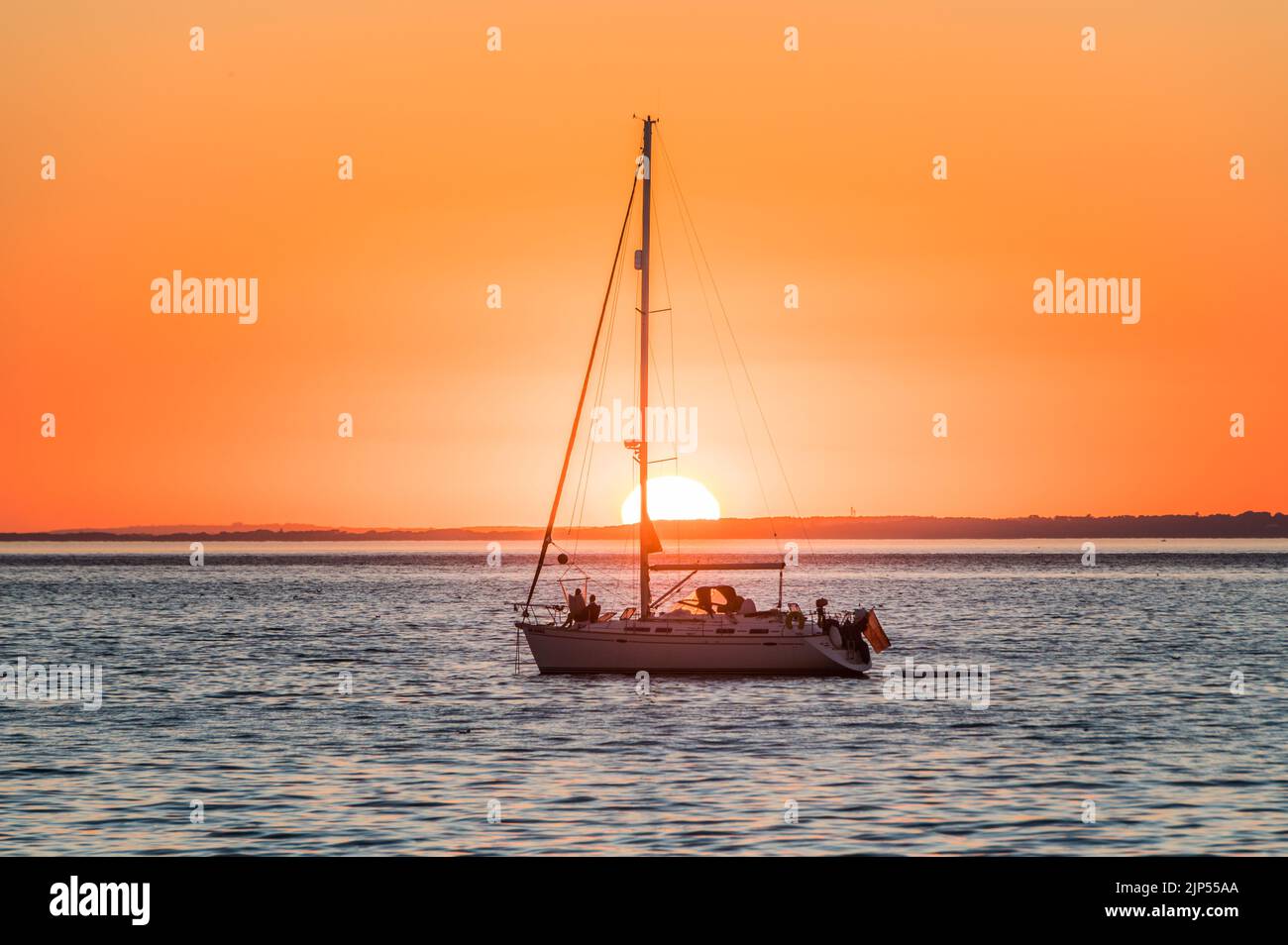 Tramonto dietro uno yatch a Totland Bay, Isola di Wight Foto Stock