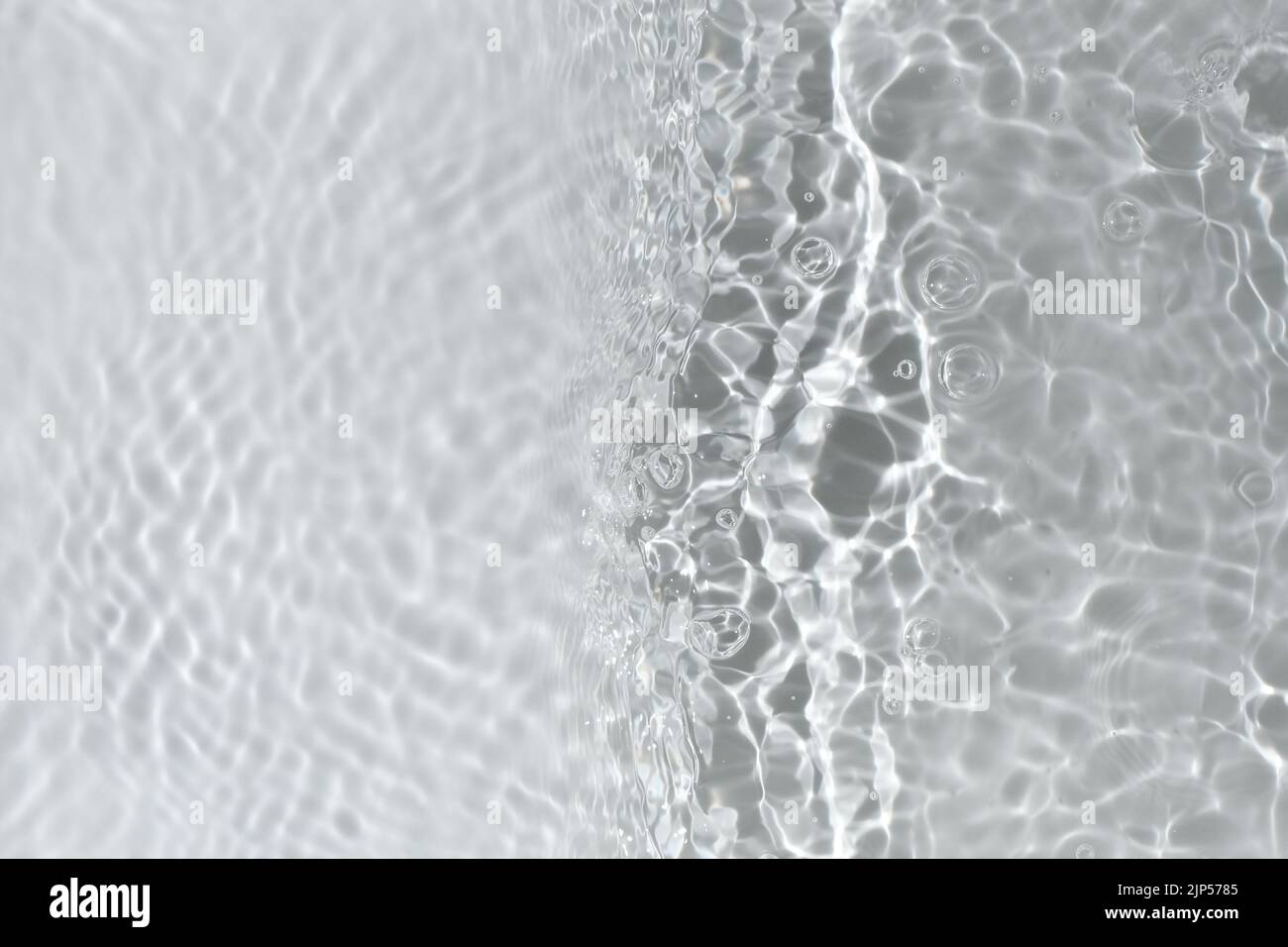Trasparente trasparente chiaro acqua calma superficie texture con onde, schizzi e bolle. Sfondo naturale astratto alla moda. Onde d'acqua bianche e grigie alla luce del sole Foto Stock