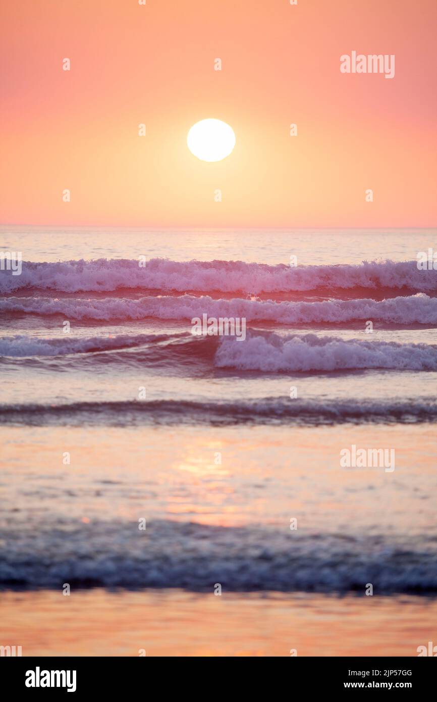 Il sole sulle onde a Polzeath. Cornovaglia, Inghilterra Foto Stock