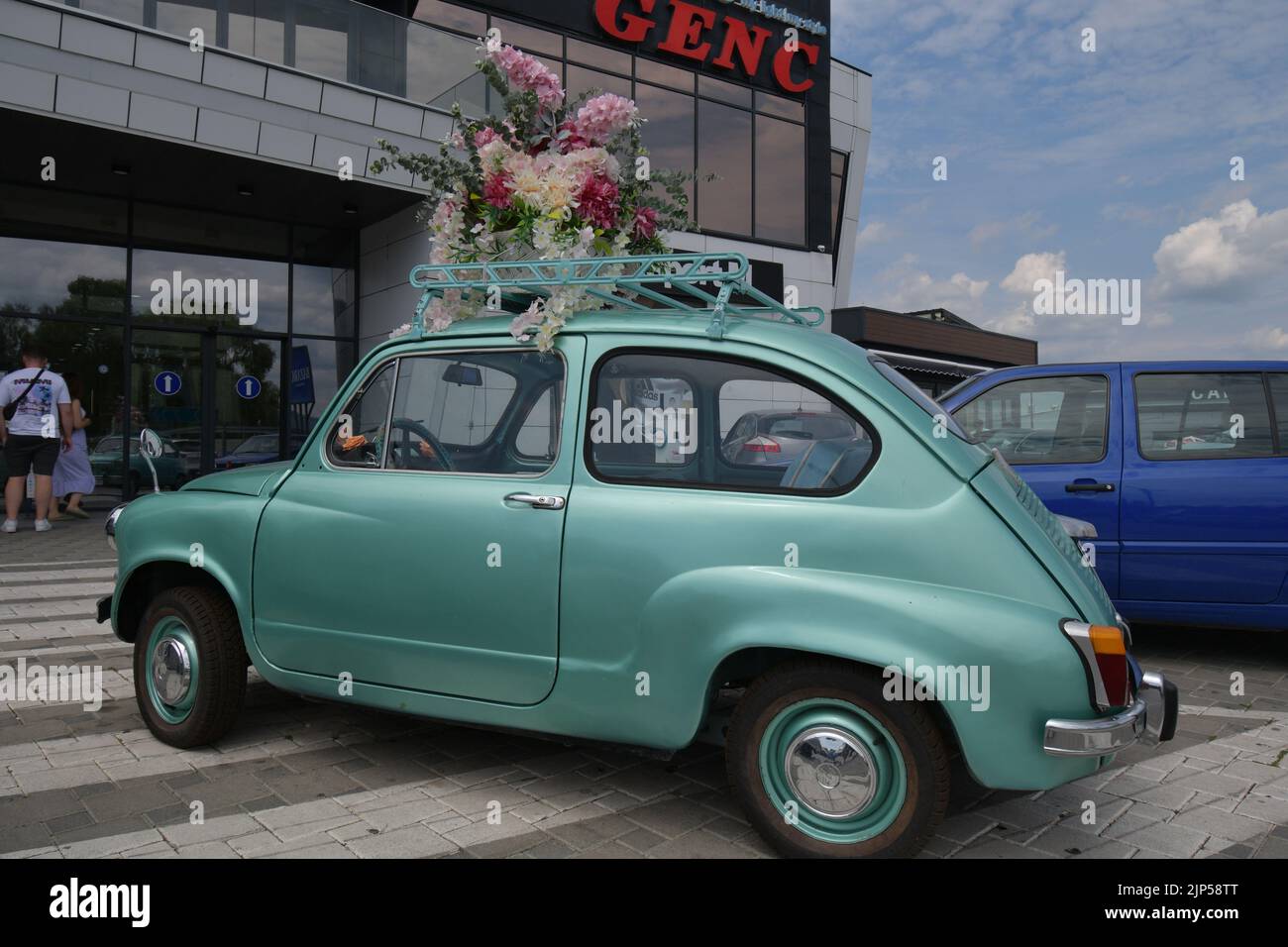 La leggendaria supermini Zastava 750 (Fiat 600) prodotta dal 1955 al 1985 parcheggiata davanti al negozio di fiori, decorata con fiori Foto Stock