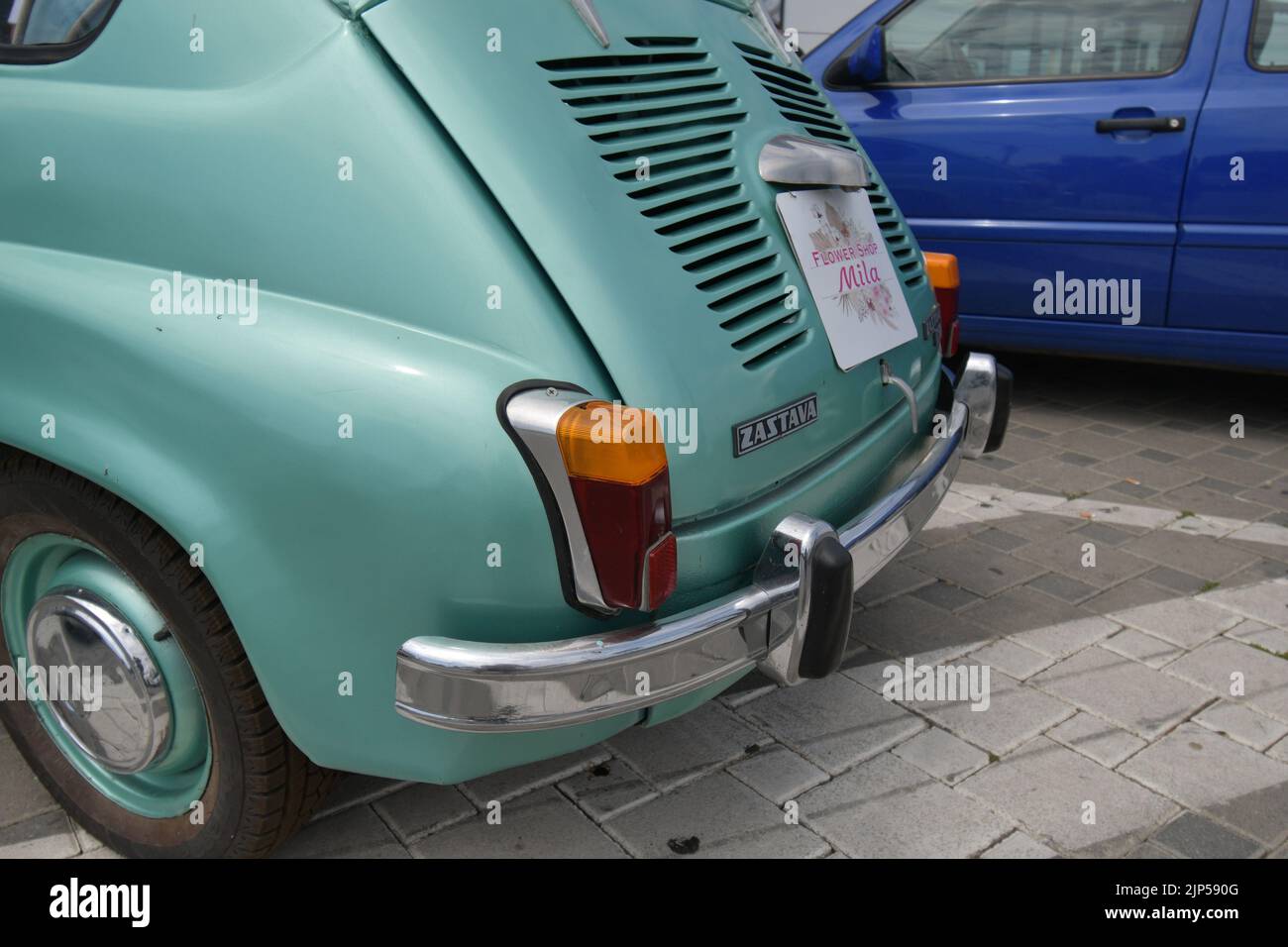 La leggendaria supermini Zastava 750 (Fiat 600) prodotta dal 1955 al 1985 parcheggiata davanti al negozio di fiori, decorata con fiori Foto Stock