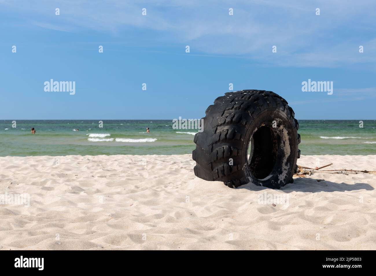 Una gomma feltro sulla spiaggia, sul litorale. Un vecchio pneumatico sulla sabbia sul lungomare. Foto Stock