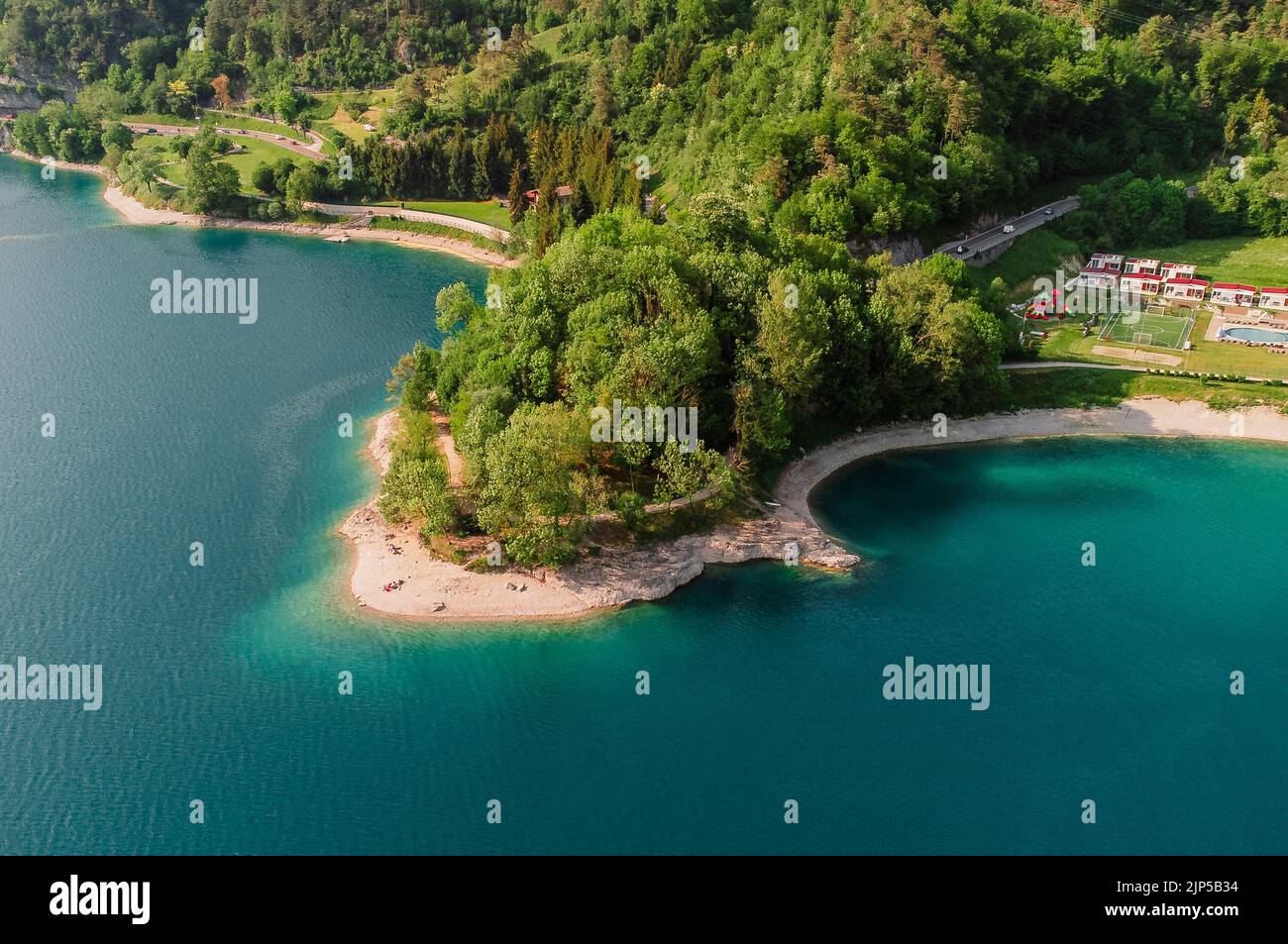 Una bella vista su un'isola con alberi e la strada sul lago Ledro in Italia Foto Stock