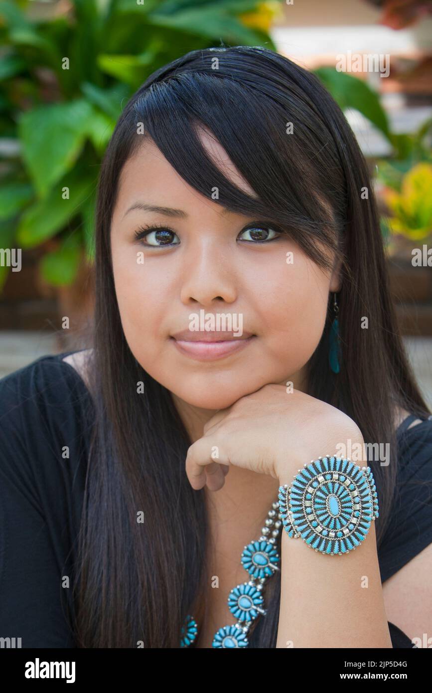 Primo piano del volto di una giovane donna Navajo, indossa una tradizionale collana turchese a fiori di squadrone e un bracciale. Foto Stock