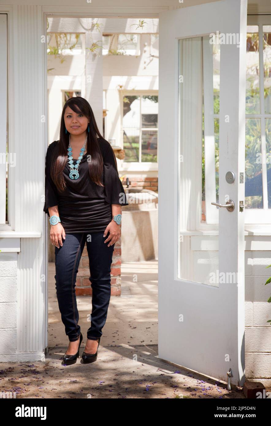 La donna nativa americana contemporanea si trova all'interno di una porta, simbolo del suo futuro. Foto Stock