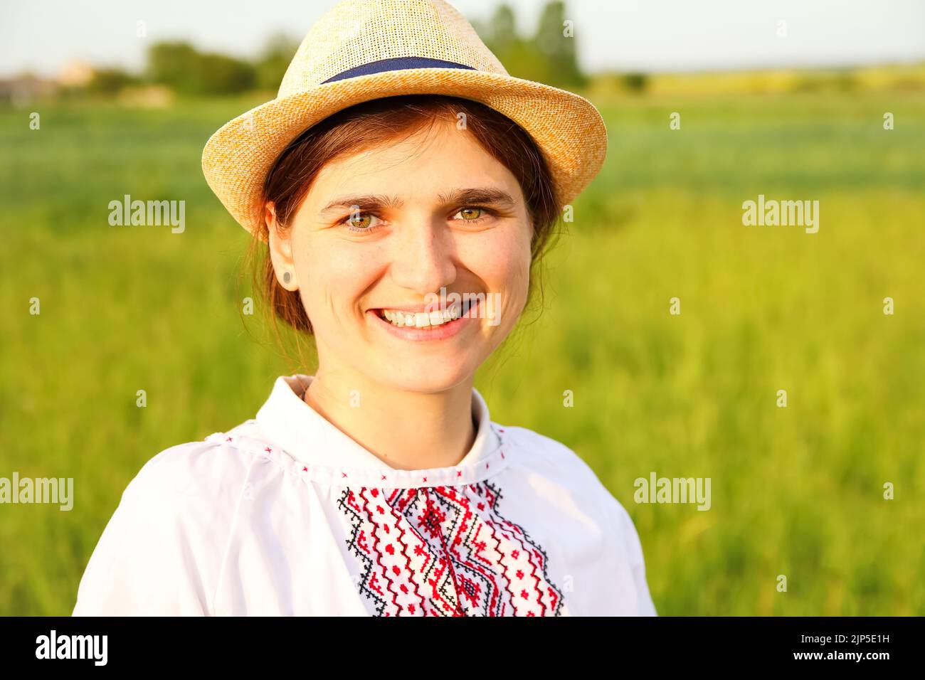 Defocus giovane donna ucraina ritratto. Prato sfondo natura. Giovani ucraini. sorridente ragazza ucraina mostrando gesto amore. Vyshyvanka Foto Stock