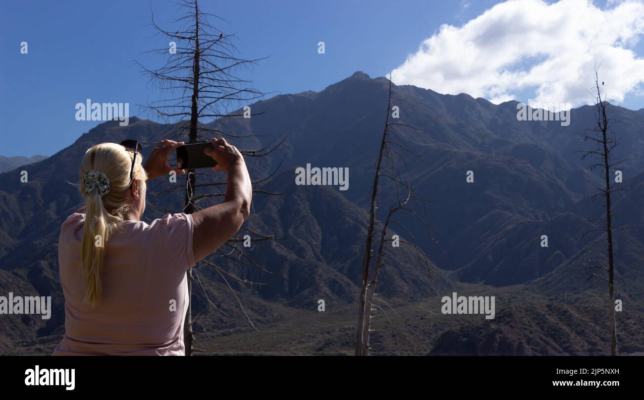 Donna bionda scattare una foto in un bellissimo scenario. Foto Stock