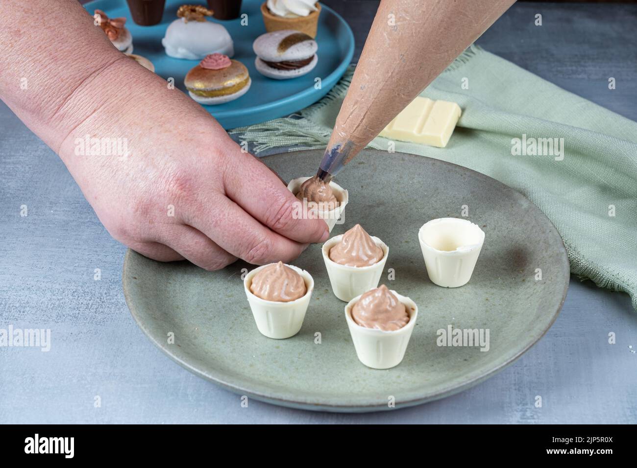 Confetter ripieno di piccole tazze di cioccolato bianco con mousse al cioccolato al latte_vista laterale. Foto Stock