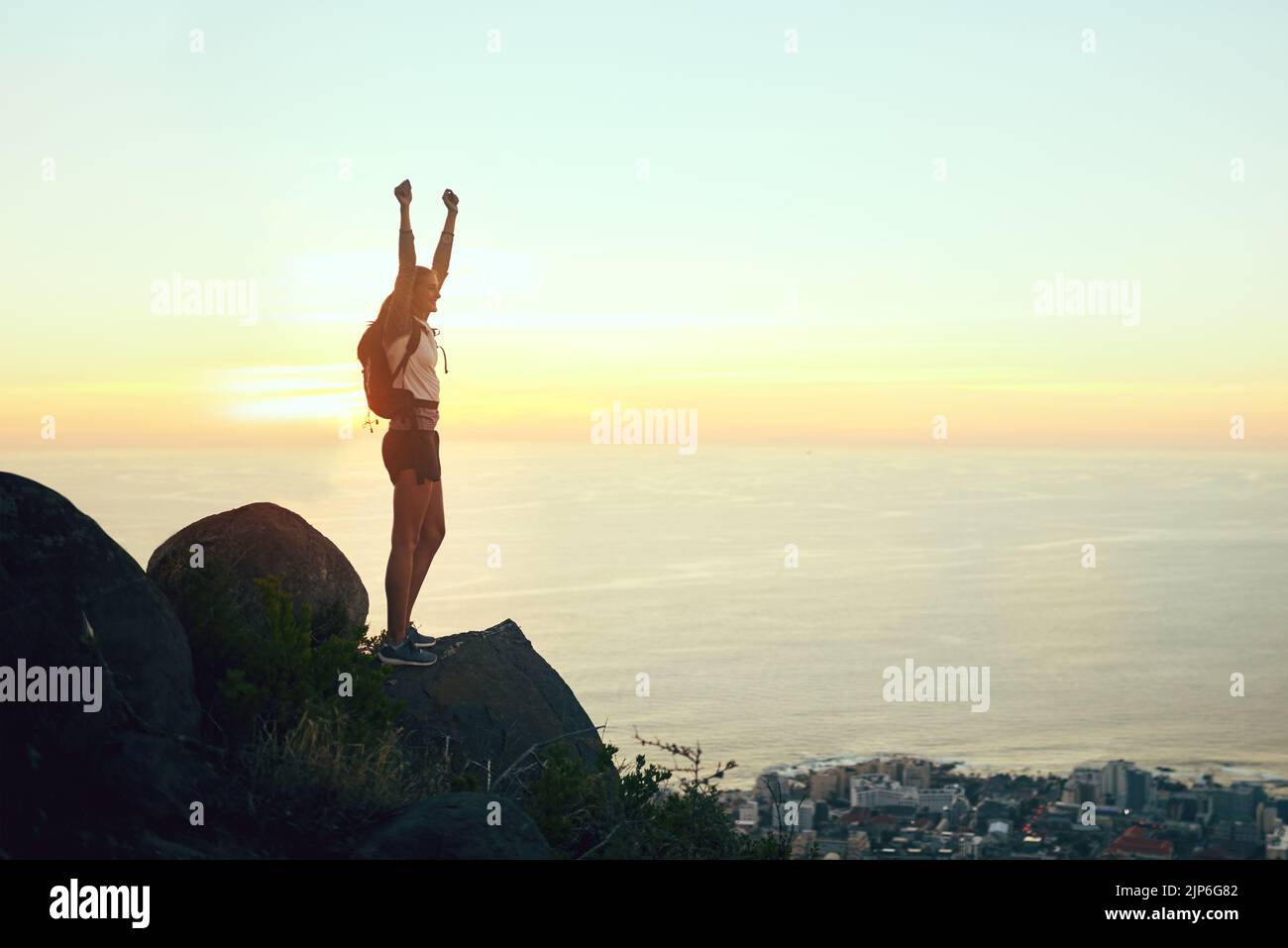 Emerge vittorioso dalle vostre sfide. Una giovane donna che festeggia mentre fuori su un'escursione attraverso le montagne. Foto Stock