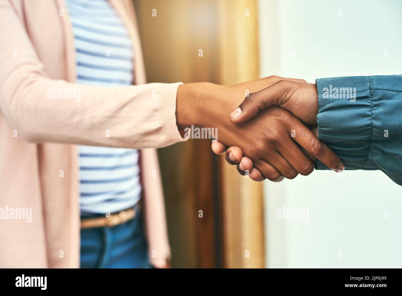 Grazie per il suo servizio di alto livello. Primo piano di un corriere che scuote le mani con un cliente mentre effettua una consegna. Foto Stock