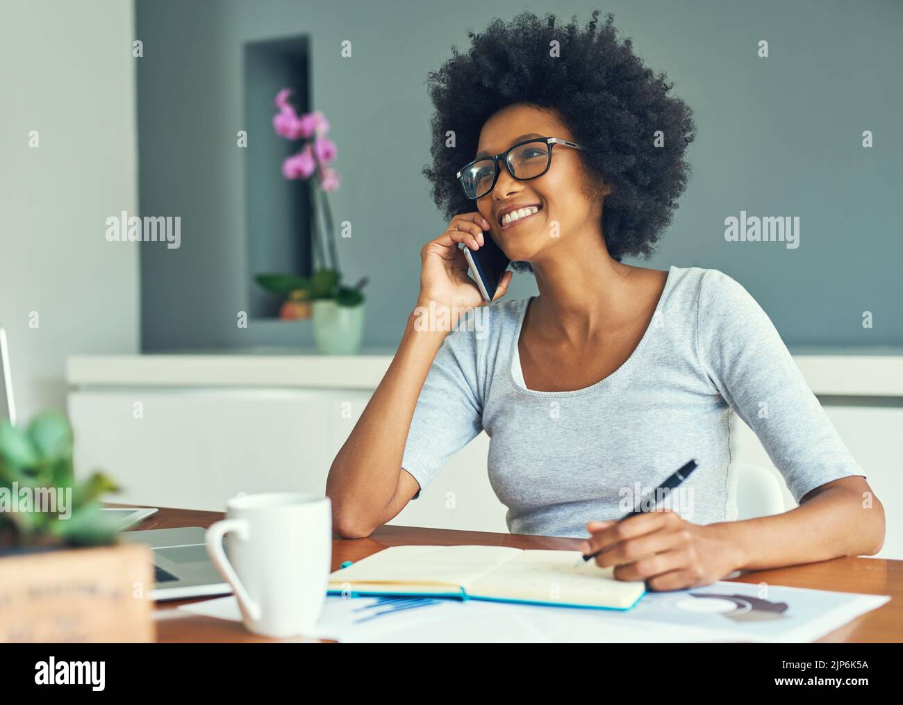 Grazie per avermi chiamato. Una giovane e attraente donna d'affari che lavora a casa. Foto Stock