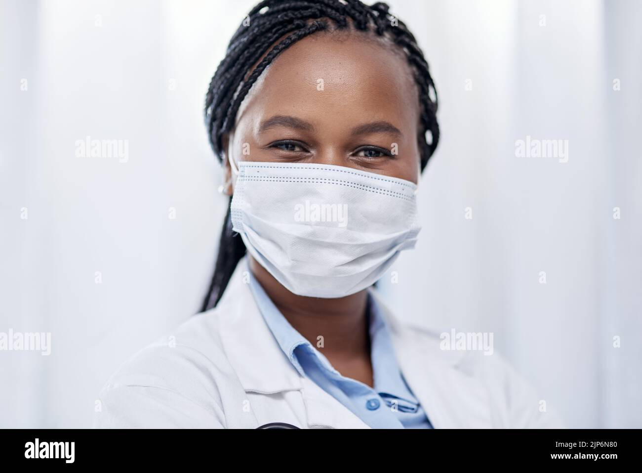 Medico indossare maschera igienica per la protezione, la sicurezza e le precauzioni nel settore sanitario. Ritratto e volto di sicuro nero medico Foto Stock