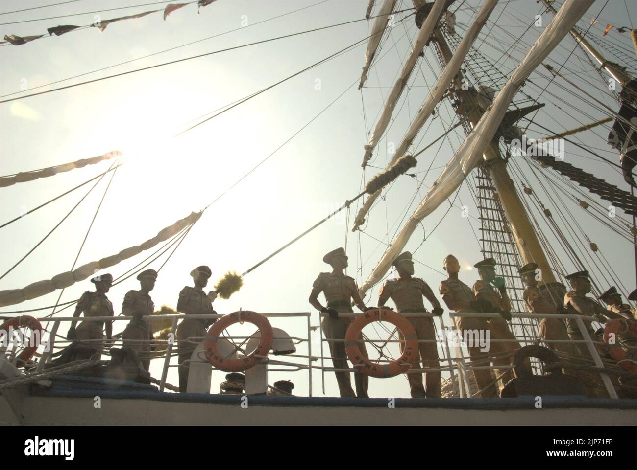 Gli ufficiali della marina indonesiana vengono fotografati contro una luce solare intensa mentre si trovano sul ponte di KRI Dewaruci (Dewa Ruci), una nave alta indonesiana, dopo che la goletta di tipo barquentino è stata aperta ai visitatori pubblici al porto di Kolinlamil (porto della Marina) a Tanjung Priok, a nord di Giacarta, Indonesia. Foto Stock