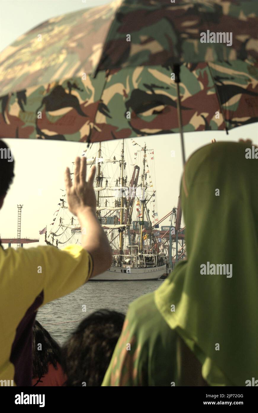 Famiglie e visitatori che si sono mossi da Arrivederci a KRI Dewaruci (Dewa Ruci), una nave alta indonesiana, come goletta di tipo barquentino che inizia a navigare dopo essere stata aperta al pubblico al porto di Kolinlamil (porto della Marina) a Tanjung Priok, nel nord di Giacarta, Indonesia. Foto Stock