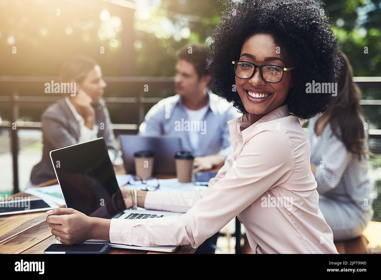 Weve condividevano nuove prospettive. Ritratto di una giovane donna d'affari che ha un incontro con i suoi colleghi in un bar. Foto Stock