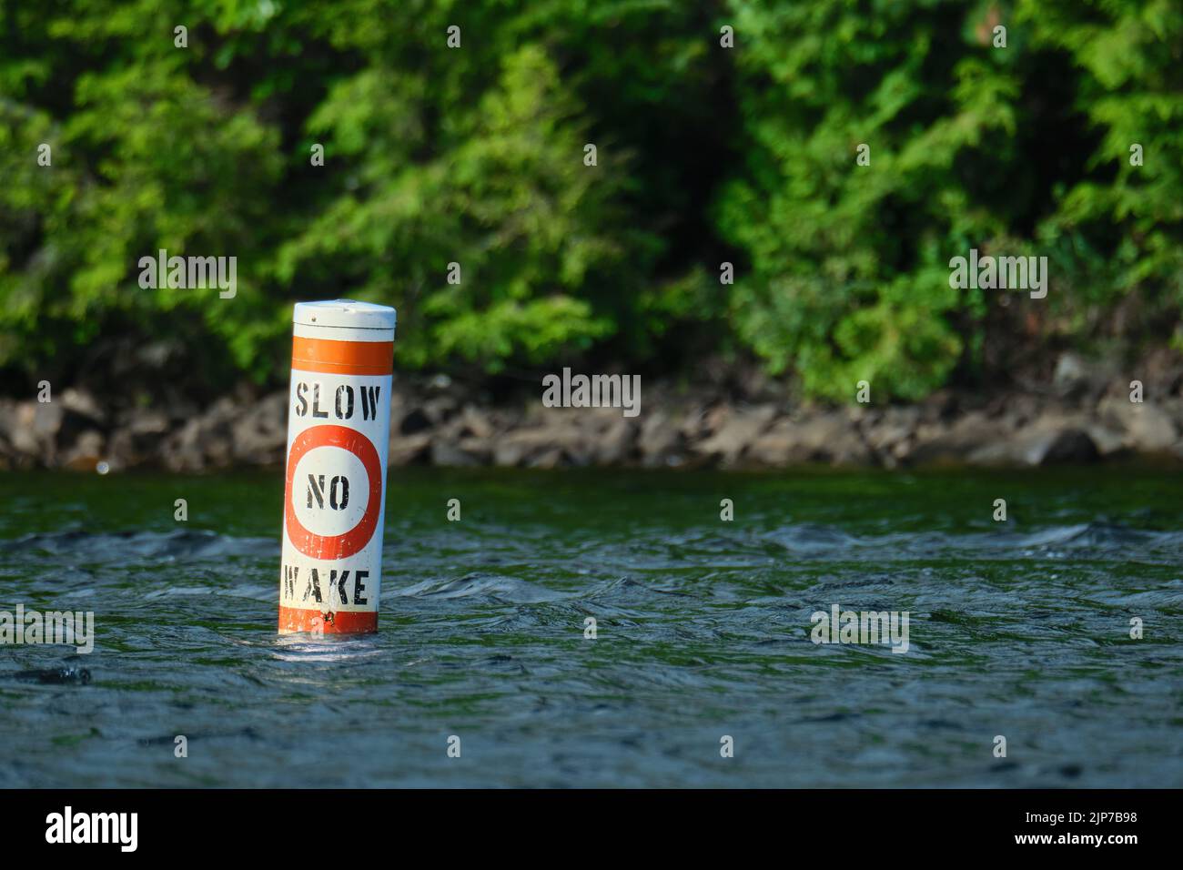Una boa che galleggia sulla superficie di un lago dice 'slow' e 'no wake', indicando che le barche dovrebbero entrare lentamente nella zona. Foto Stock