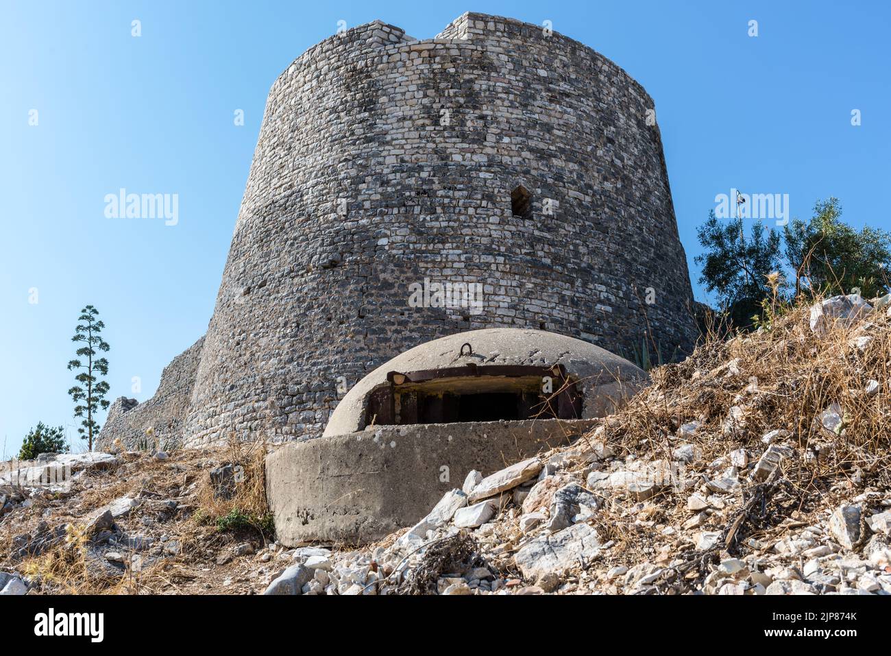 Il castello di Lekuresi e un bunker militare in cemento in primo piano a Saranda, Albania Foto Stock