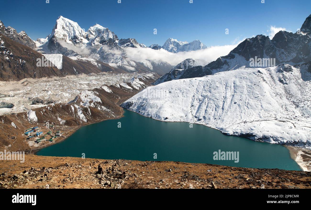 Dudh Pokhari Tso o lago di Gokyo, villaggio di Gokyo, ghiacciaio di Ngozumba, picco di Arakam tse e picco di chola tse da Gokyo Ri - trekking al campo base di Cho Oyu, Khumbu Foto Stock