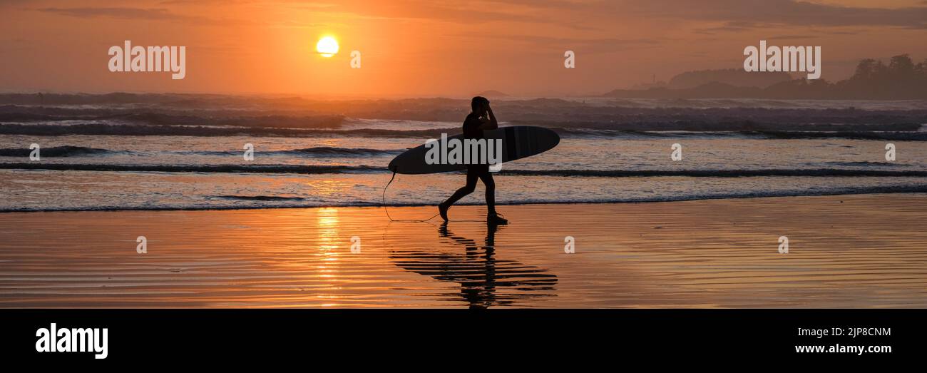Tofino Vancouver Island Pacific Rim Coast, surfisti con surf durante il tramonto in spiaggia, surfisti silhouette Canada Vancouver Island Tofino Vancouver Islander Island Foto Stock