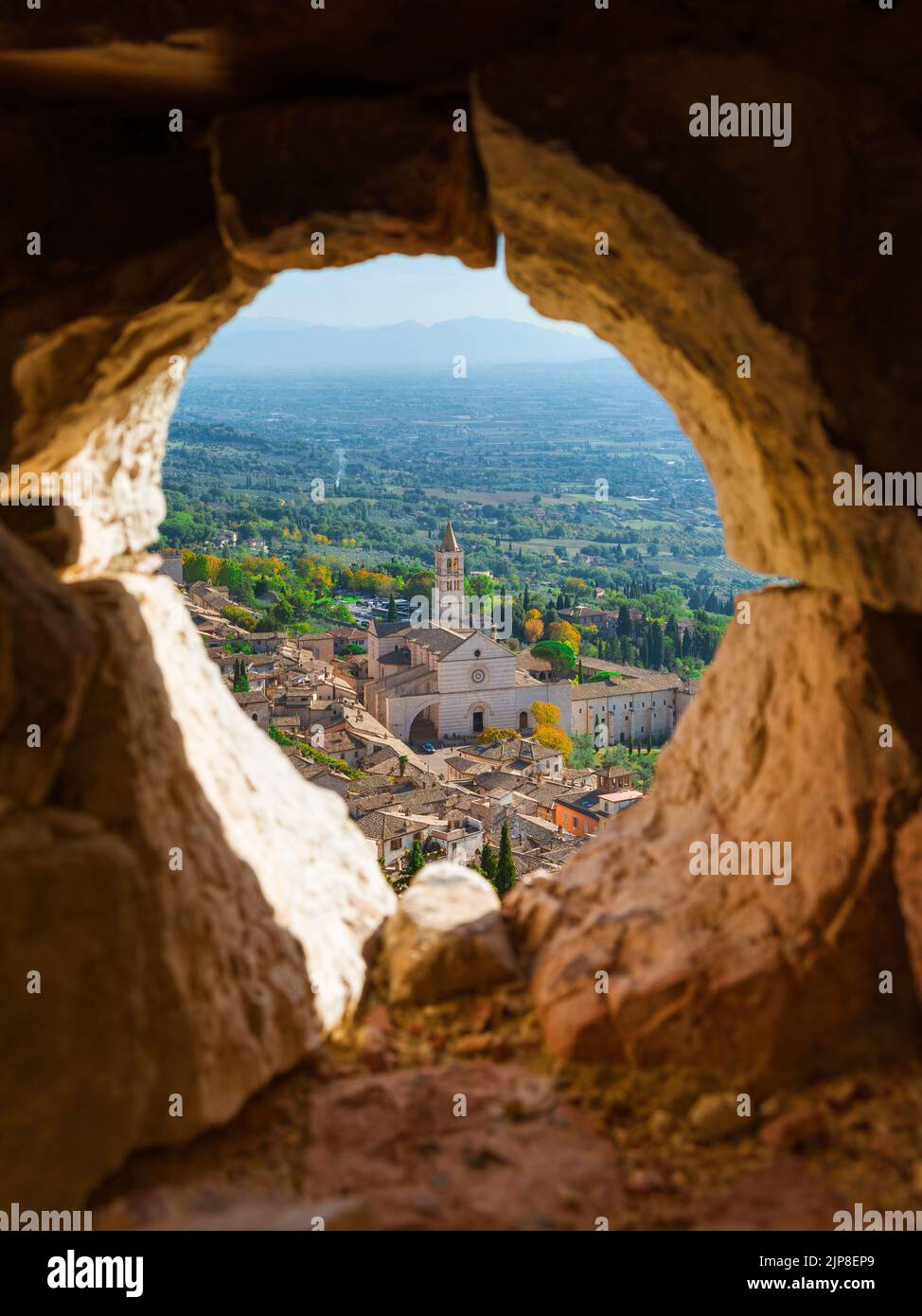Vista su Assisi bellissimo centro storico con la Basilica medievale di Santa Chiara dalle mura in rovina della Rocca maggiore Foto Stock