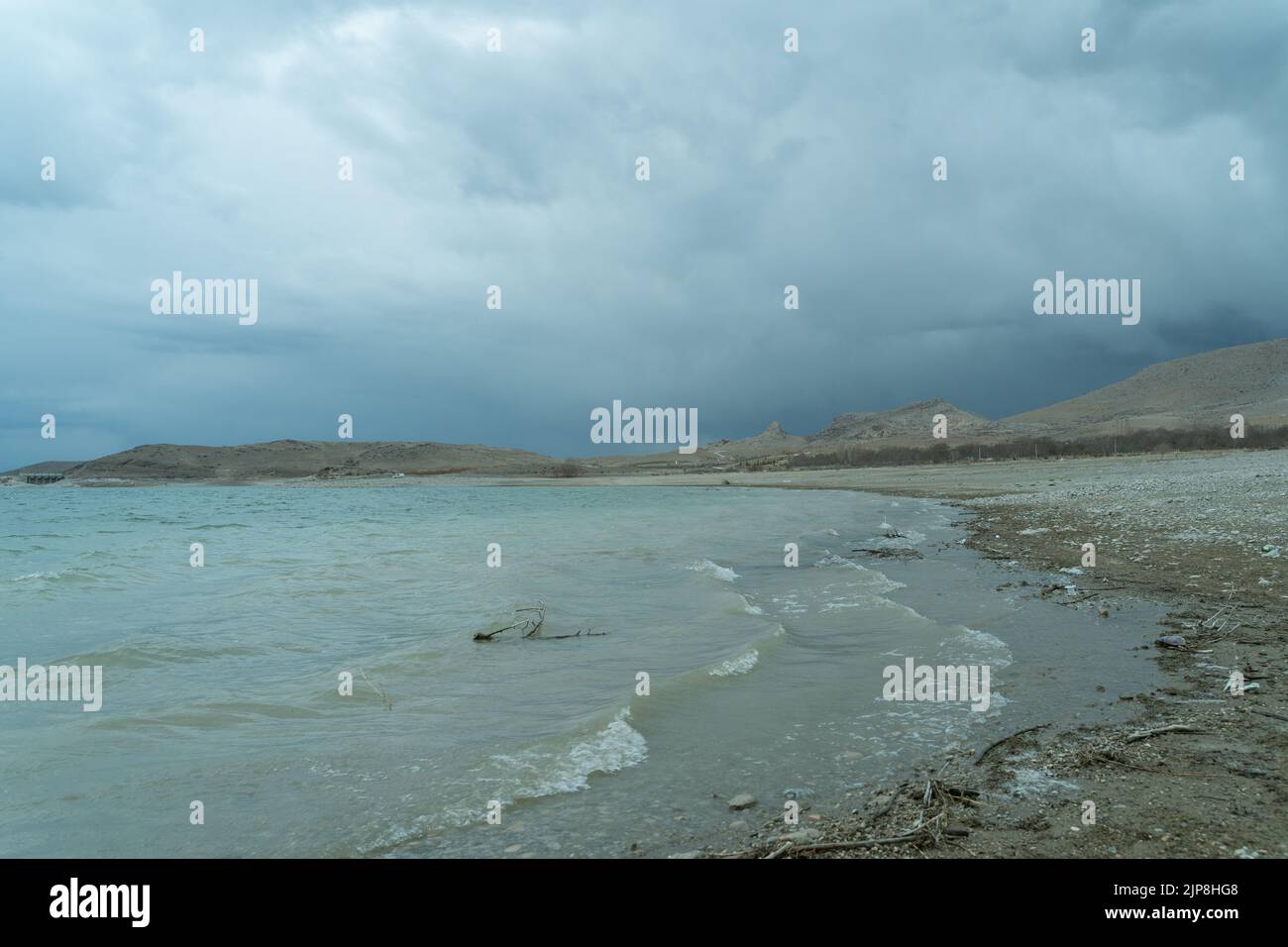Riva del lago ondulata e cielo nuvoloso. Foto Stock