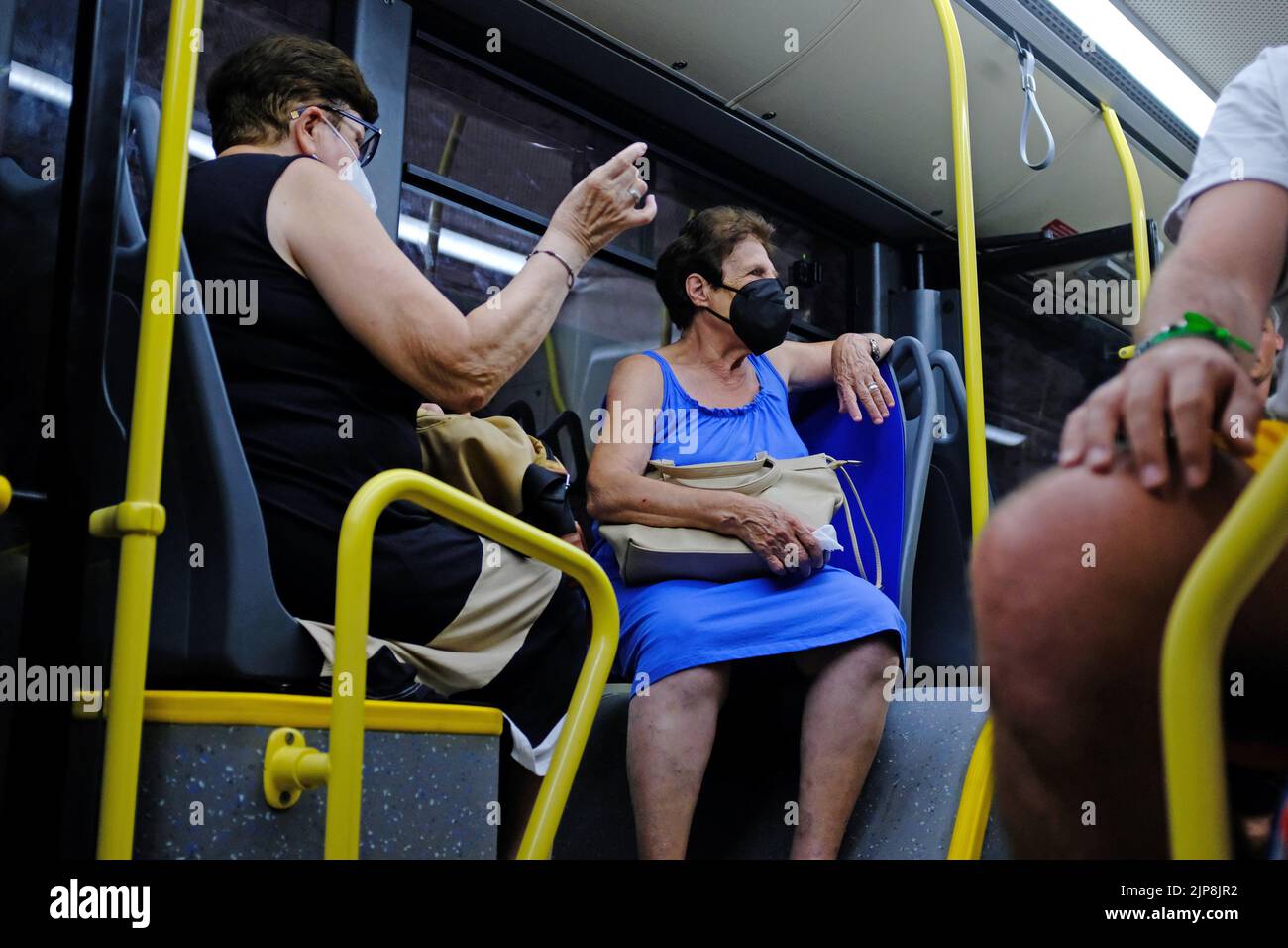 Italiani che viaggiano su un autobus con maschere facciali Foto Stock