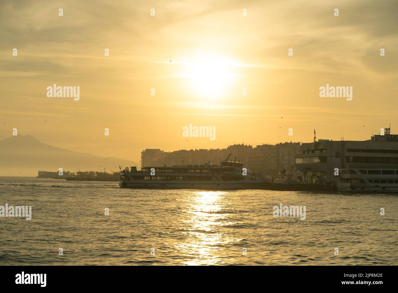 Smirne, Karsiyaka, Turchia - 5 novembre 2021: Traghetto che si avvicina al molo al tramonto. Smirne, molo di Karşıyaka nel Mar Egeo. Foto Stock