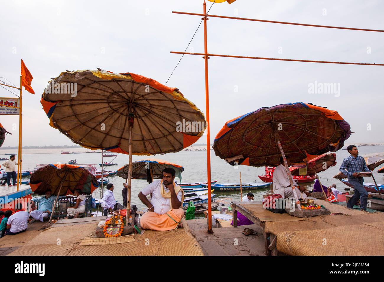 Sacerdote seduto sotto un ombrello enorme a Dashwamedh Ghat sul fiume Ganga Ganges, Varanasi, Banaras, Benaras, Kashi, Utttar Pradesh, India Foto Stock