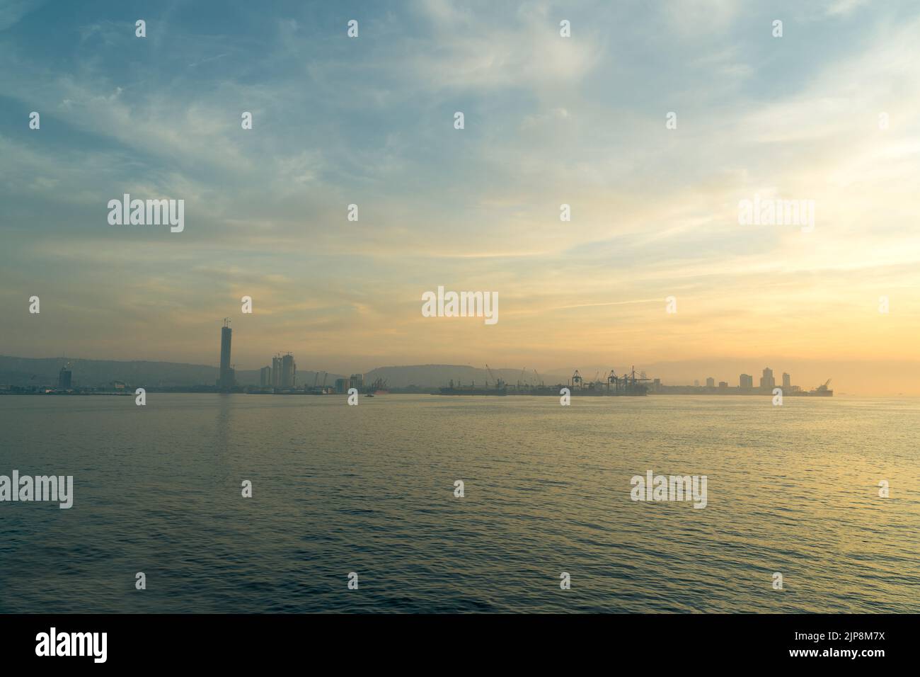 Tramonto sulla città all'orizzonte, grattacielo e vista del porto all'orizzonte. Foto Stock