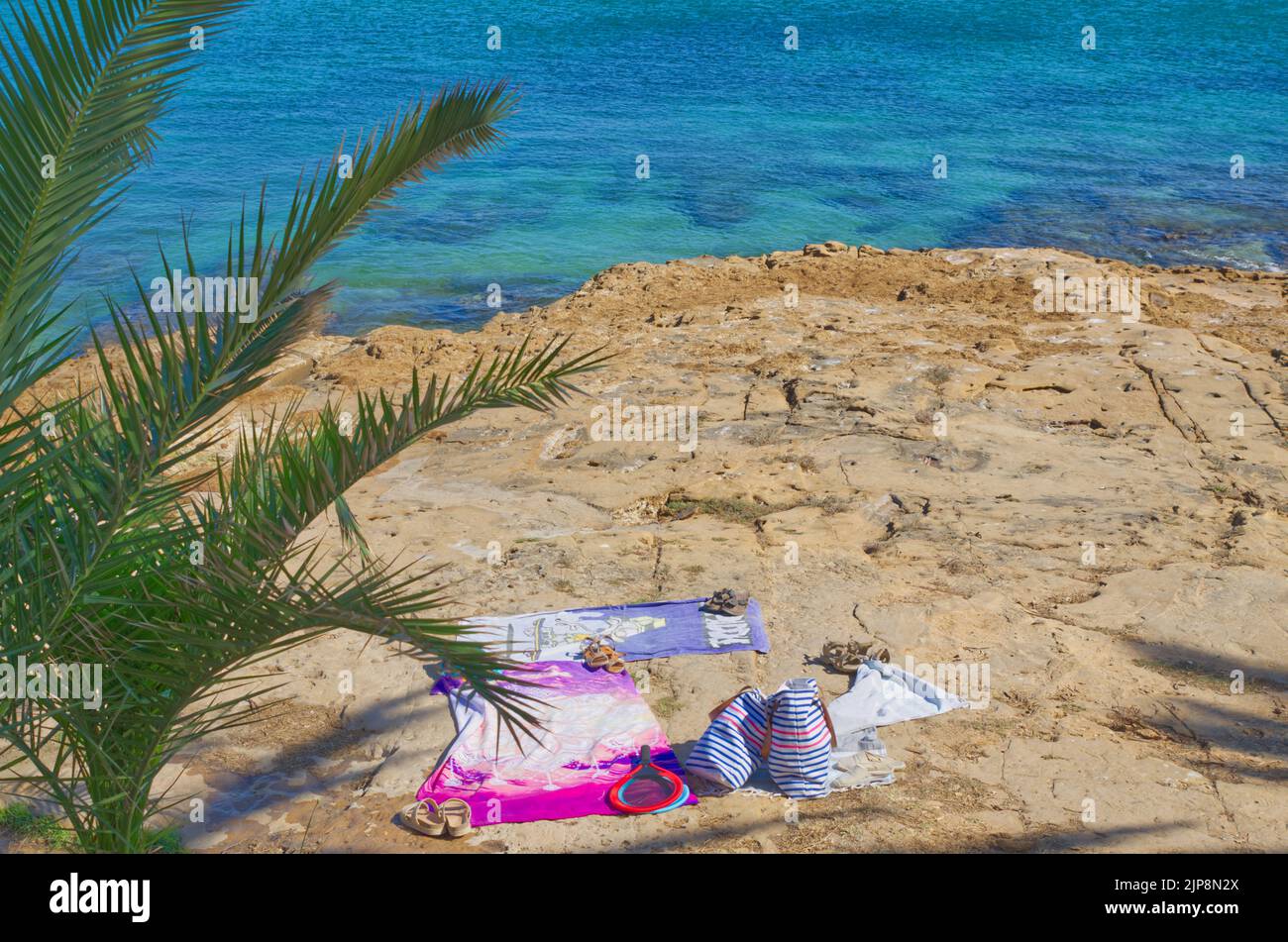 Portugal telo da spiaggia con cappello, occhiali da sole e infradito su naturista di sabbia Foto Stock