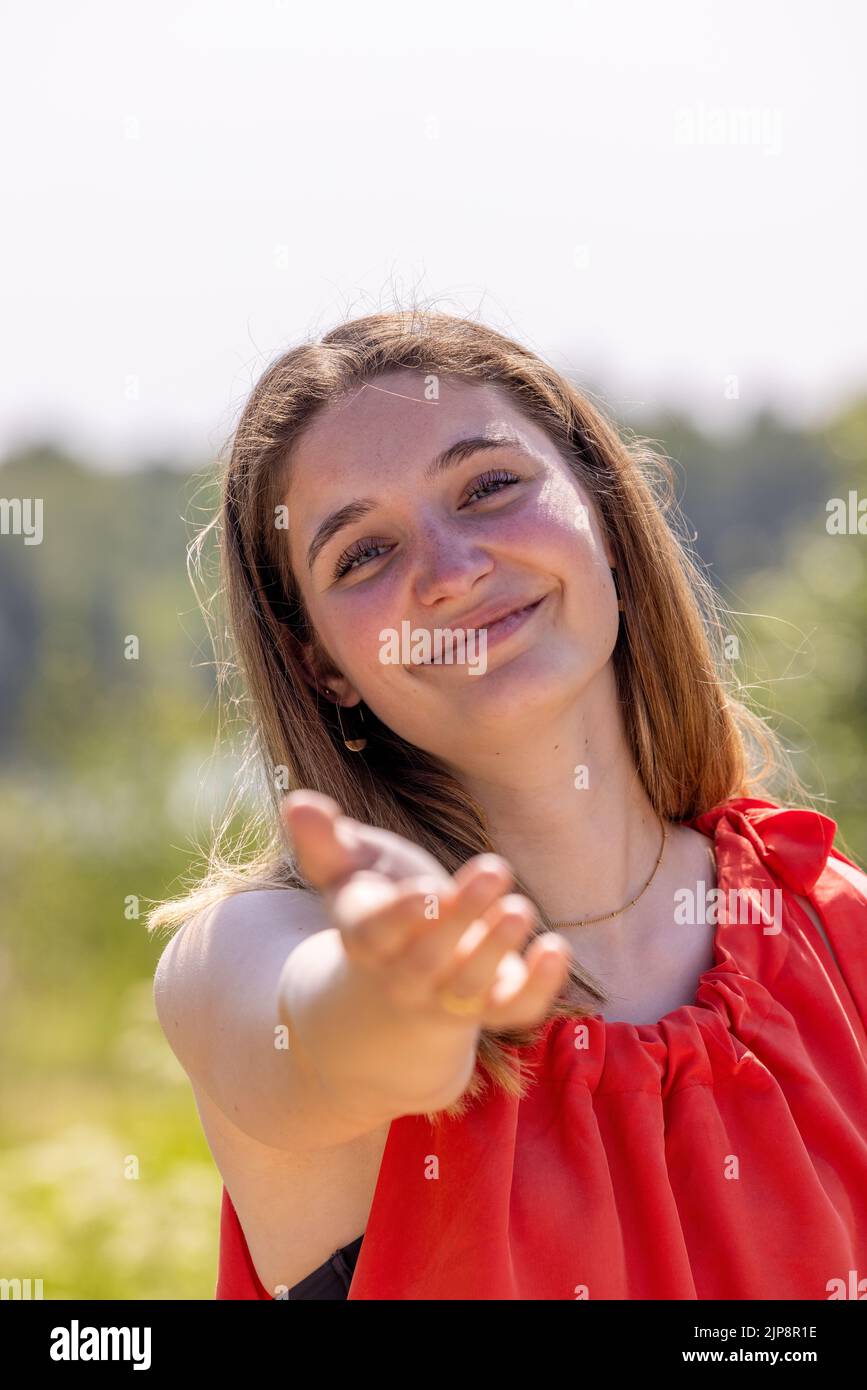 Ritratto di una giovane donna felice che raggiunge la mano del suo ragazzo o partner mentre cammina in una campagna rurale zona. Coppia che si gode un'escursione nella natura. Foto di alta qualità Foto Stock