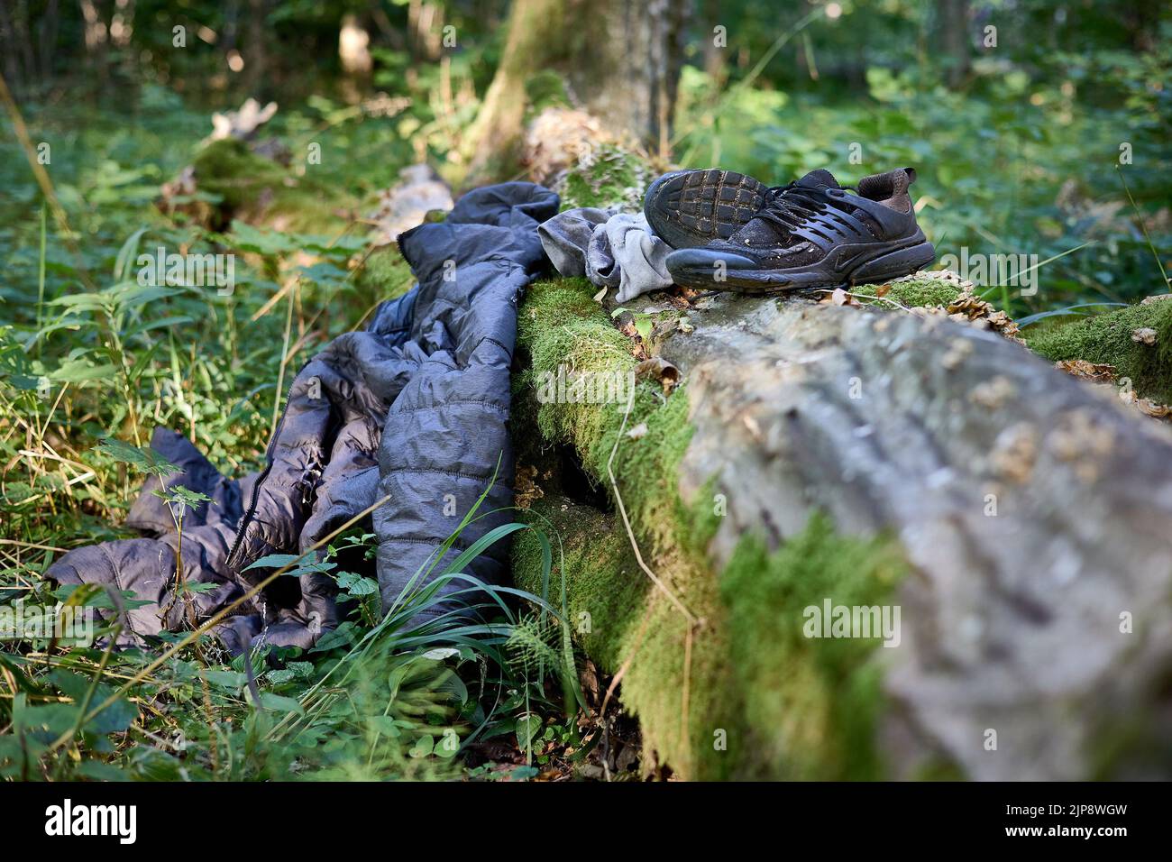 Puszcza Bialowieska, Polonia. 16th ago, 2022. Indossato abiti abbandonati da Said, rifugiato dal Congo (RDC) che è stato vagare nei boschi per 4 giorni evitando pattuglie di frontiera polacche. Dopo aver ricevuto nuovi vestiti, cibo dagli attivisti di Fundacja Ocalenie (ONG che sostiene gli immigrati) sta tornando in strada per la zona con un segnale mobile per chiamare sorella in Germania per organizzare l'ultima tappa di questo viaggio di rifugiati. Egli nasconde ancora di eludere le autorità e di fare forti spinte verso la Bielorussia. Le ONG lavorano nelle foreste di confine in condizioni molto difficili, ma anche in una situazione giuridica difficile. Forniscono cibo, assistenza medica Foto Stock