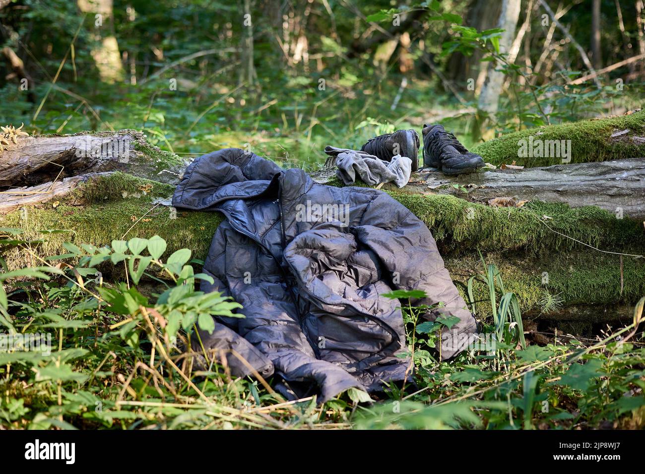 Puszcza Bialowieska, Polonia. 16th ago, 2022. Indossato abiti abbandonati da Said, rifugiato dal Congo (RDC) che è stato vagare nei boschi per 4 giorni evitando pattuglie di frontiera polacche. Dopo aver ricevuto nuovi vestiti, cibo dagli attivisti di Fundacja Ocalenie (ONG che sostiene gli immigrati) sta tornando in strada per la zona con un segnale mobile per chiamare sorella in Germania per organizzare l'ultima tappa di questo viaggio di rifugiati. Egli nasconde ancora di eludere le autorità e di fare forti spinte verso la Bielorussia. Le ONG lavorano nelle foreste di confine in condizioni molto difficili, ma anche in una situazione giuridica difficile. Forniscono cibo, assistenza medica Foto Stock