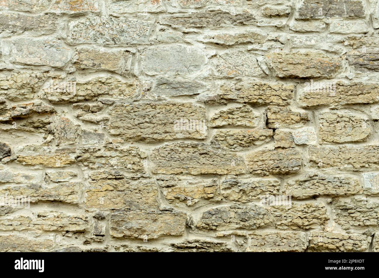 Robusto muro in pietra tagliato di giallo e beige, adatto per sfondi Foto Stock