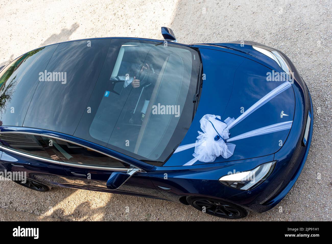 14 maggio 2022 Castelgomberto Italia: Una vettura Tesla blu vista dall'alto, decorata con un arco bianco per una cerimonia nuziale Foto Stock