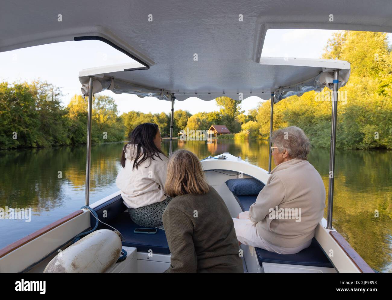 Attività per il tempo libero e stile di vita di campagna; tre donne in una barca sul Tamigi a Oxfordshire in estate luce del sole sera in agosto, Oxfordshire, Regno Unito Foto Stock