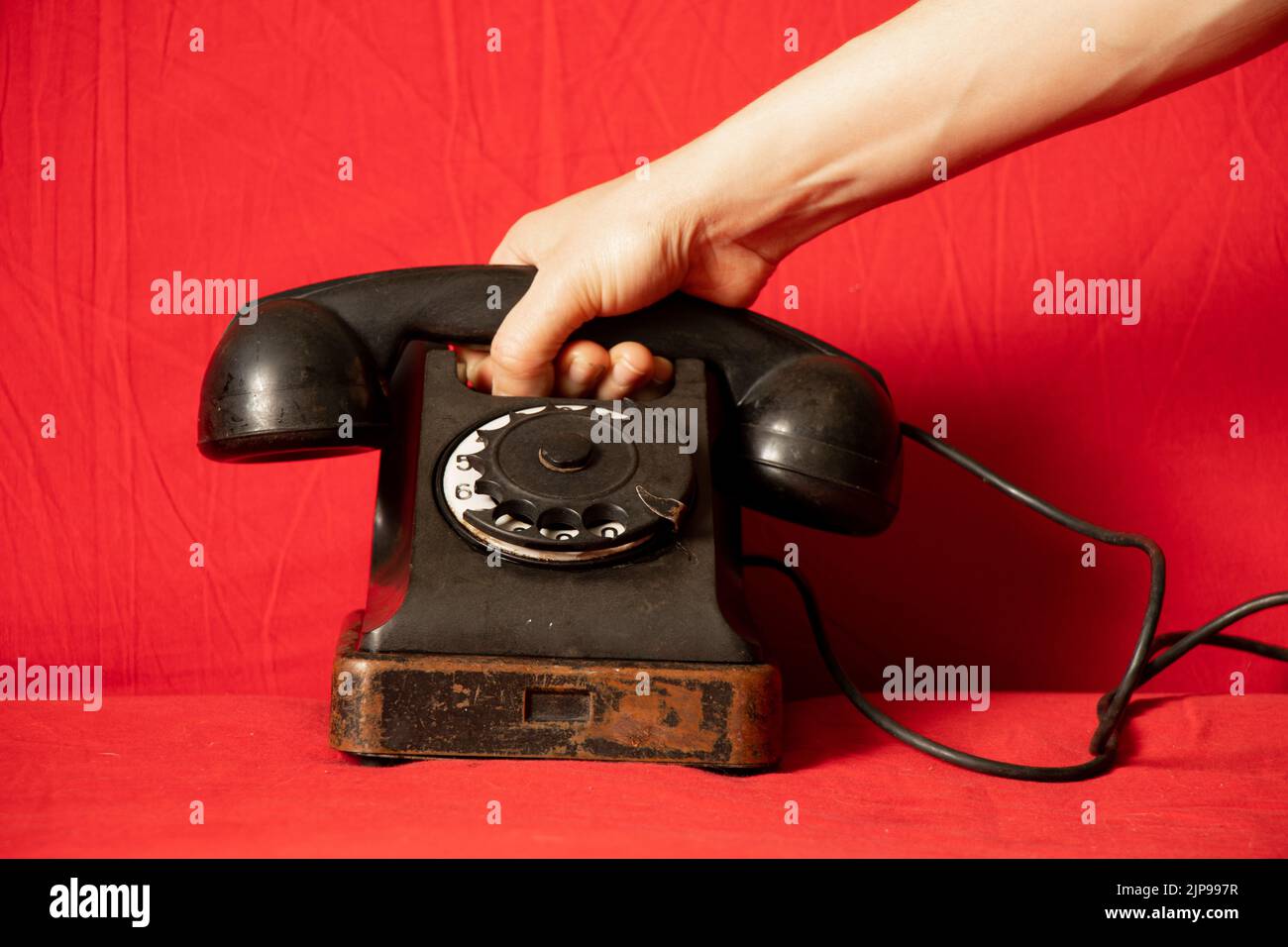 Vecchio retro telefono nero e la mano della donna closeup, chiamata al telefono, tecnologia Foto Stock